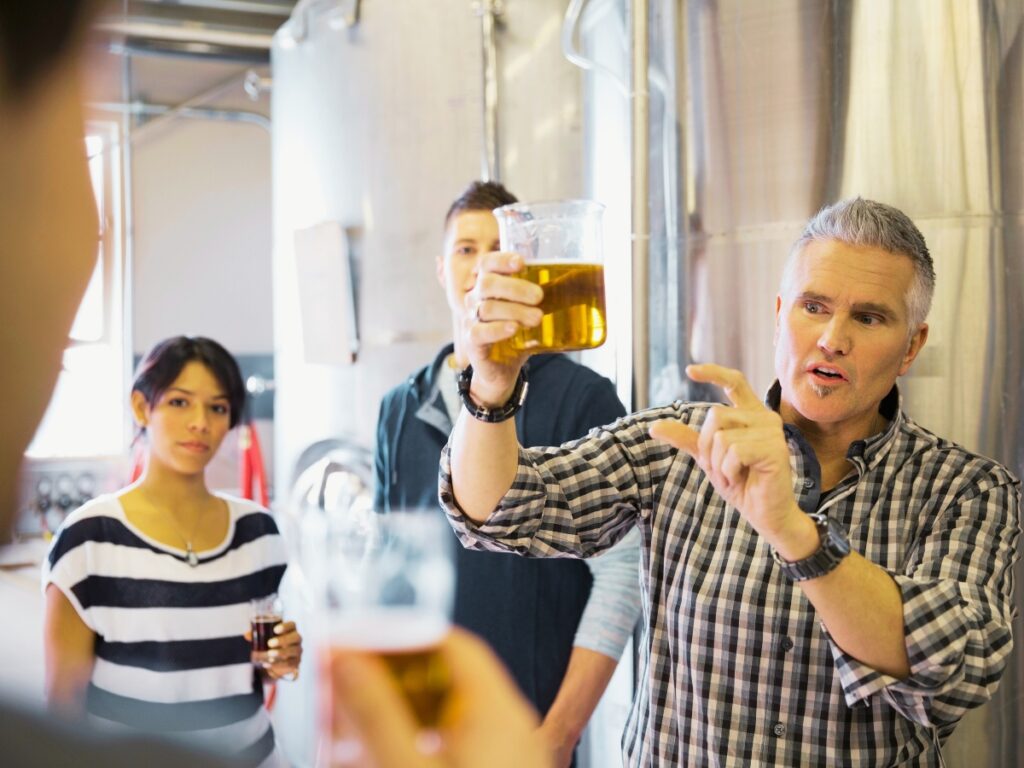 Beer tour in Asheville - Brewery tour guide explaining beer in brewery Image by Hero Images from Getty Images